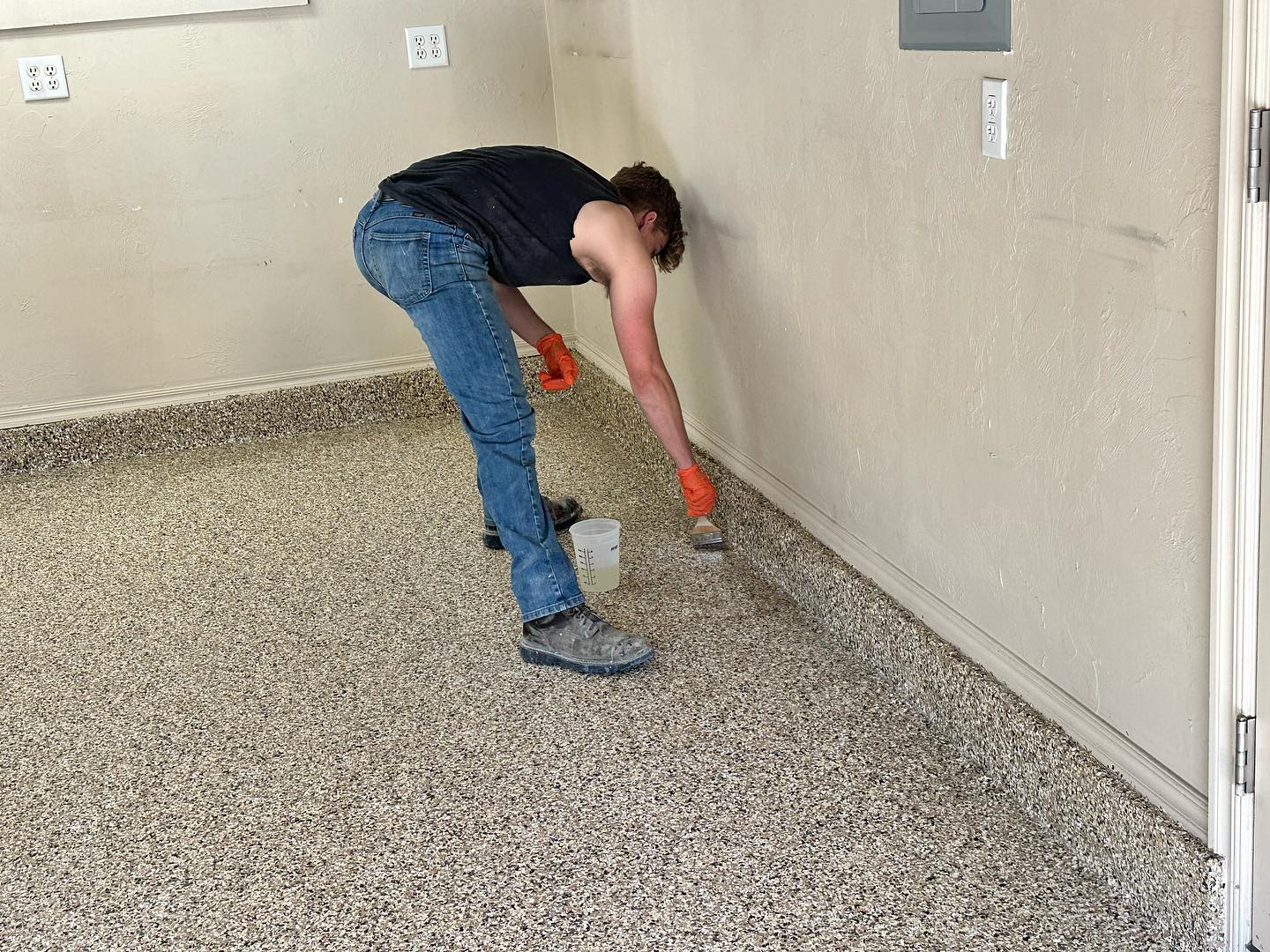 worker finishing garage floor coating